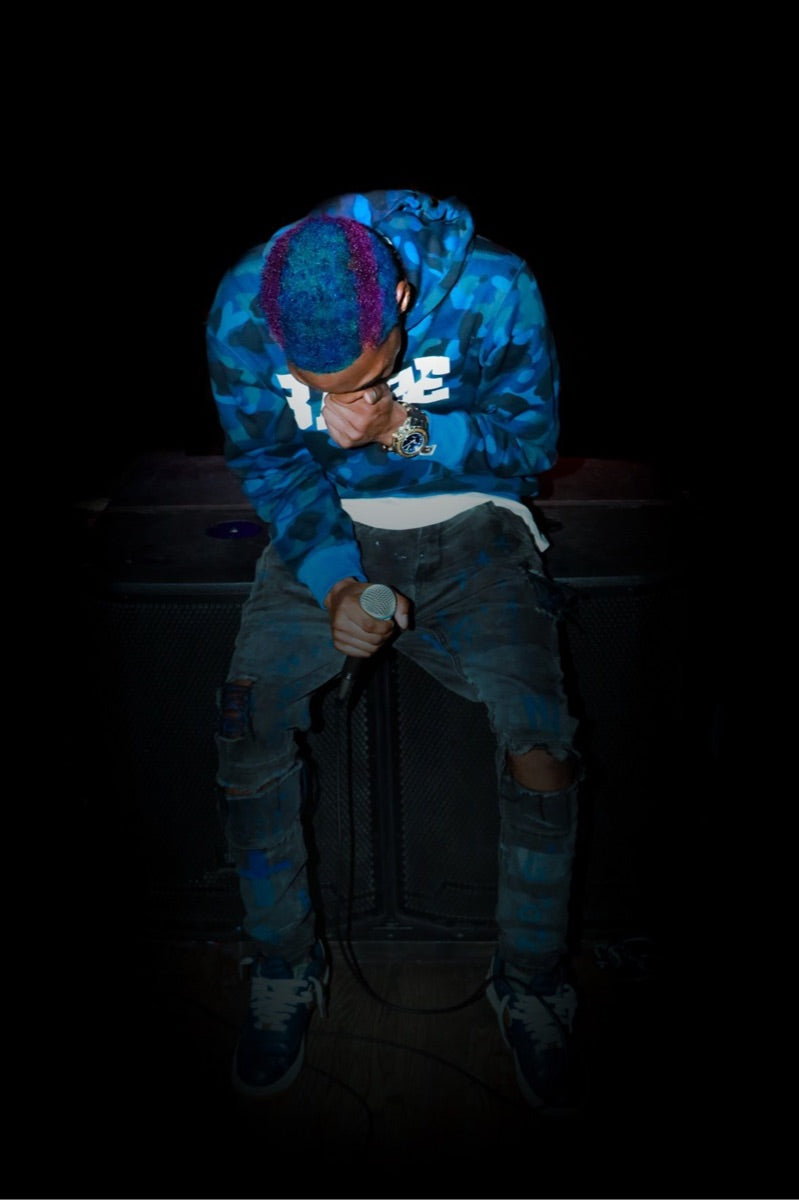 Ÿusuf ULTRA performing onstage beneath blue light